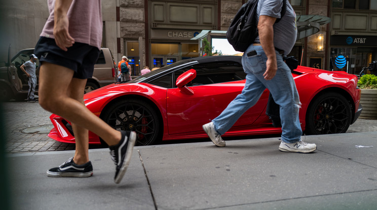 Emberek sétálnak egy Lamborghini mellett New Yorkban, a Wall Street pénzügyi negyedében 2022. július 18-án. / Fotó: Getty Images