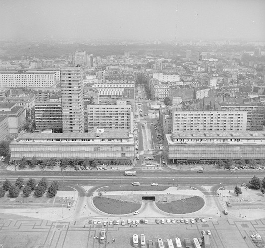 <strong>Wczoraj: Domy Towarowe Centrum</strong>
<br></br>
Po zakończeniu II wojny światowej w Polsce zaczęła się odradzać gospodarka wolnorynkowa. W latach 1945-1948 komuniści przystąpili do przekształcenia gospodarki w całkowicie scentralizowaną. Działania te rozpoczęto od przejmowania majątków, fabryk, a później zajęto się handlem.
<br></br>
29 listopada 1947 roku ukazało się Zarządzenie Ministra Przemysłu i Handlu o utworzeniu przedsiębiorstwa „Powszechne Domy Towarowe – przedsiębiorstwo państwowe wyodrębnione” z siedzibą w Warszawie. Przedsiębiorstwo podlegało pod Ministra Przemysłu i Handlu i przedmiotem jego działalności było prowadzenie handlu detalicznego w domach towarowych i filiach
<br></br>
Na zdj. widok z Pałacu Kultury i Nauki. Widoczna ul. Marszałkowska, Domy Towarowe „Centrum” i ul. Kniewskiego (ob. Złota), rok 1971. Autor: Rutowska Grażyna. Ze zbiorów Narodowego Archiwum Cyfrowego. www.nac.gov.pl.
<br></br>