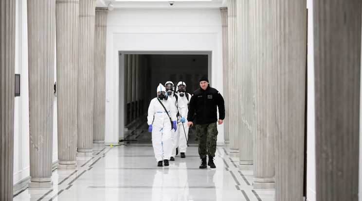 A koronavírus-járvány miatt védőruhát viselő egészségügyi alkalmazottak fertőtlenítést végeznek a lengyel parlamenti alsóháznak, a szejmnek otthont adó épületben, Varsóban 2020. március 31-én. / Fotó: MTI/EPA-PAP/Wojciech Olkusnik