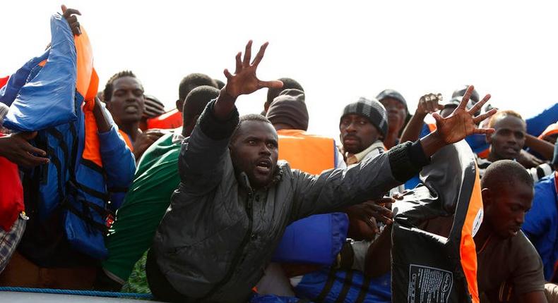 A group of 104 sub-Saharan Africans on board a rubber dinghy reach out for life jackets tossed to them by rescuers of the NGO Migrant Offshore Aid Station (MOAS) some 25 miles off the Libyan coast, in this October 4, 2014 file photo.    REUTERS/Darrin Zammit Lupi/Files