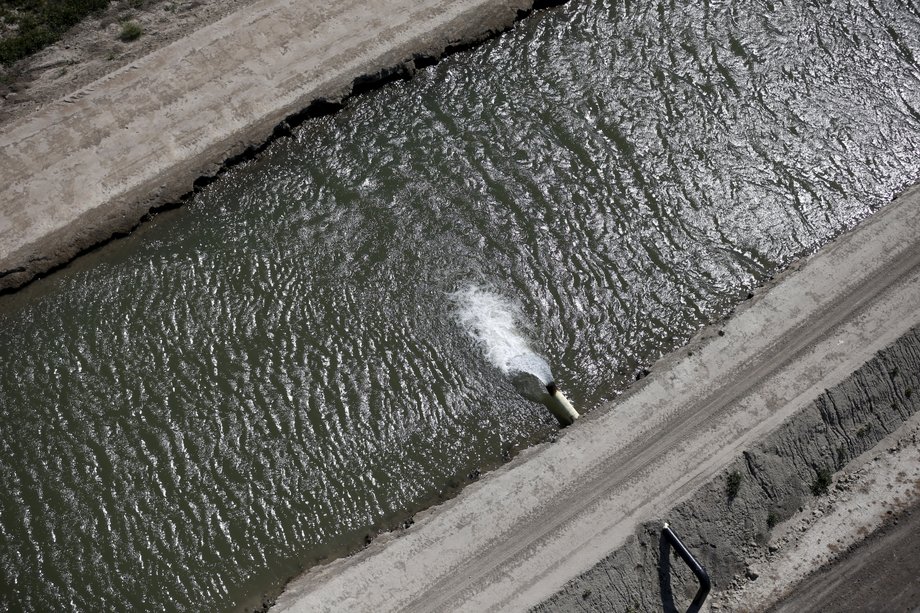 Water pours into a dried-out canal in Los Banos.