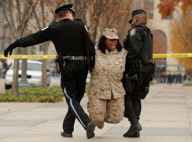 Policja aresztuje Evelyn Thomas z grupy GetEQUAL, której 13 członków przykuło się do ogrodzenia Białego Domu w proteście przeciwko łamaniu praw gejów, lesbijek, biseksualistów i transseksualistów w amerykańskiej armii