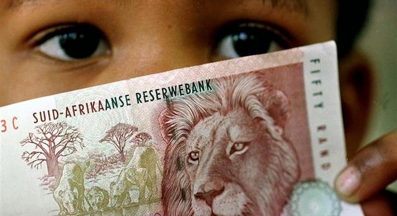 A South African child holds a 50 rand note , file.
