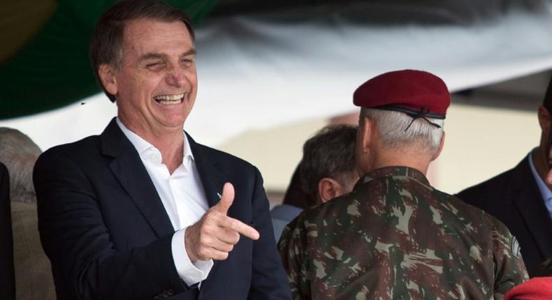 Brazil's President-elect Jair Bolsonaro (L), pictured at a graduation ceremony November 24, 2018, is embroiled in a crisis over campaign financing