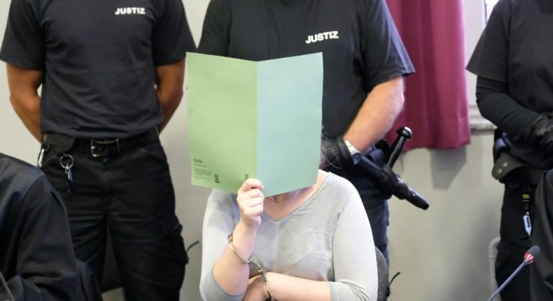 Defendant Xenia I covers her face in a courtroom in Dessau, Germany, on August 4 2017