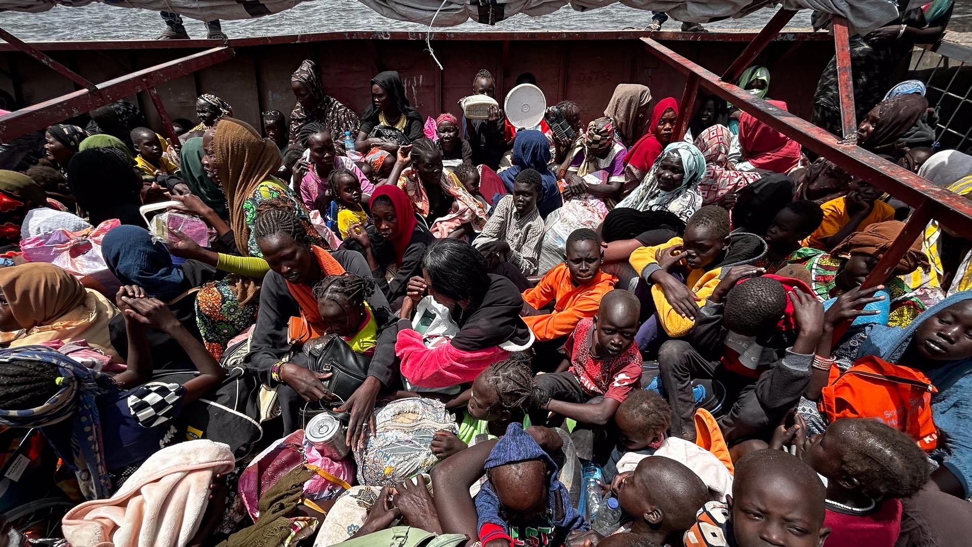 Rejs do obozu Malakal w górę Nilu trwa dwa dni. Repatrianci siedzą na własnych bagażach