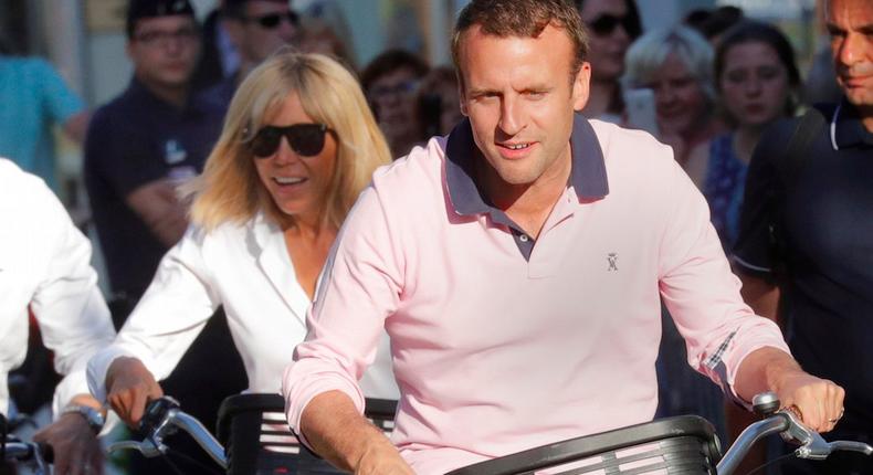 French President Emmanuel Macron and his wife Brigitte Trogneux ride their bicycles as they leave their home in Le Touquet, France June 17, 2017.