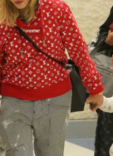 Stylowa Madonna w bluzie Supreme na lotnisku z rodziną - Noizz