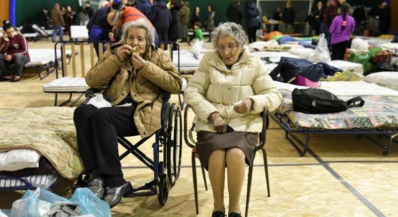 Two elderly women sit in a tent set up for the residents of Montereale after a 5.7-magnitude earthquake struck the Italian region, on January 18, 2017
