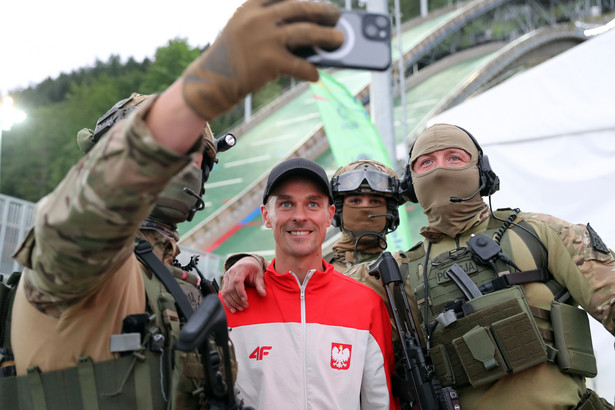 Piotr Żyła (C) pozuje do zdjęcia z funkconariuszami oddziałów specjalnych policji, ochraniających imprezę przed konkursem skoków narciarskich w Zakopanem