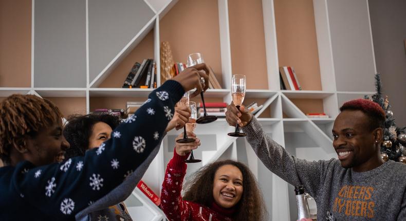 Group of friends celebrating with champagne around the holidays [Photo: Ekaterina Bolovtsova]