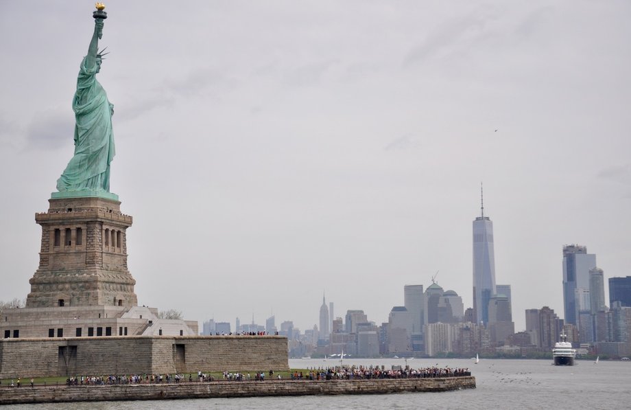 Symbole Nowego Jorku - Statua Wolności, a w tle drapacze chmur na Manhattanie. 