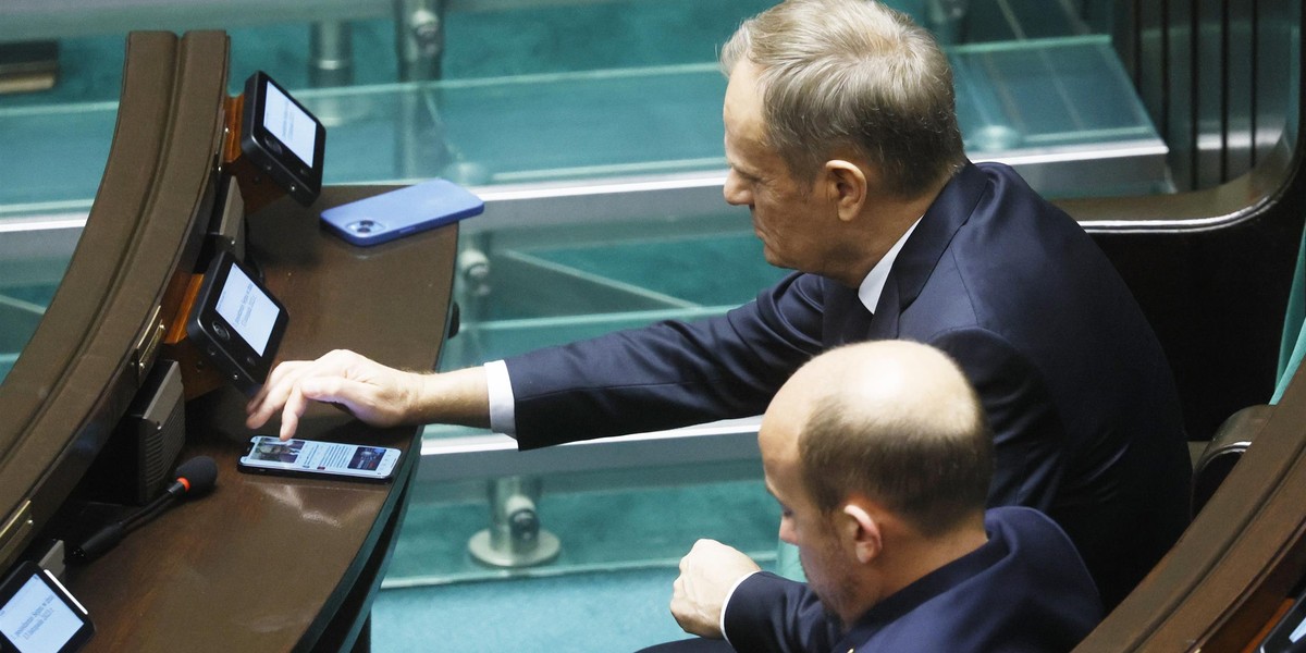 Donald Tusk korzysta z telefonu na oczach kamer