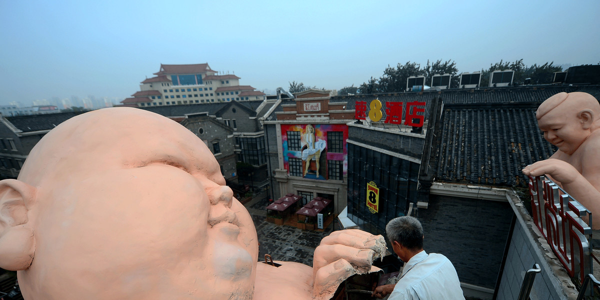A man demolishes a statue in Jinan in China's Shandong province.