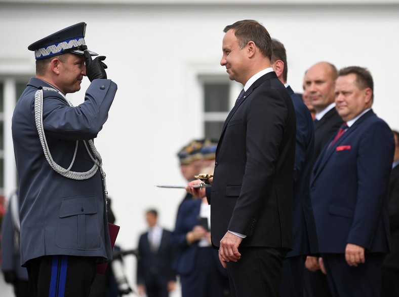 Andrzej Szymczyk (z lewej) odbiera gwiazdki generała policji z rąk prezydenta Andrzeja Dudy (w środku). Za prezydentem stoi ówczesny szef MSW Mariusz Błaszczak. Warszawa, 2 września 2016 r.