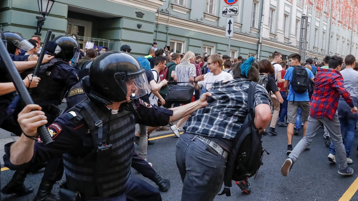 Police officers chase protesters during a rally against planned increases to the nationwide pension 