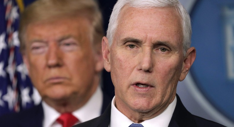 President Donald Trump listens as Vice President Mike Pence speaks at a coronavirus briefing in February 2020.