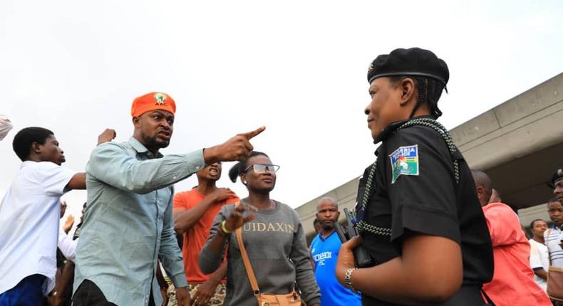 A RevolutionNow protester challenges a police officer during a demonstration in Surulere, Lagos on Monday, August 5, 2019 [Sahara Reporters]
