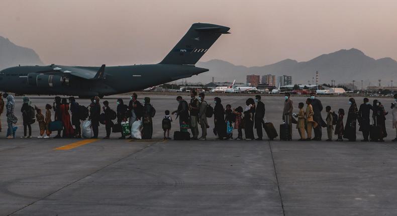 Evacuees wait to board a C-17 at Hamid Karzai International Airport in Kabul, Afghanistan, August 23, 2021.
