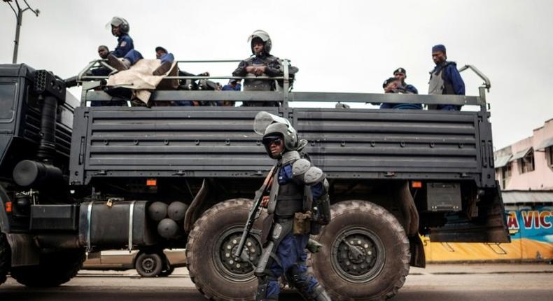 A policeman walks in front of a police truck as the Congolese capital Kinshasa is gripped by a strike on October 19, 2016