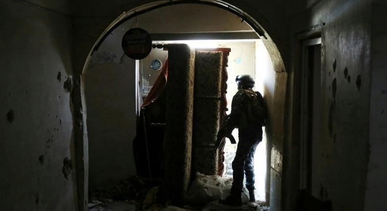 A member of the Iraqi forces, consisting of the Iraqi federal police and the elite Rapid Response Division, secures a building as troops push into the Old City in Mosul on March 19, 2017