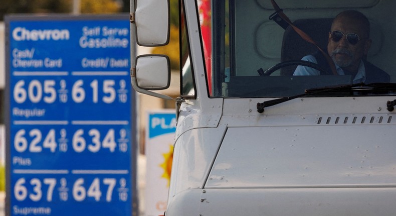 A U.S. postal worker puts his seatbelt on after filing up his vehicle at a gas station in Garden Grove, California, U.S., March 29, 2022.