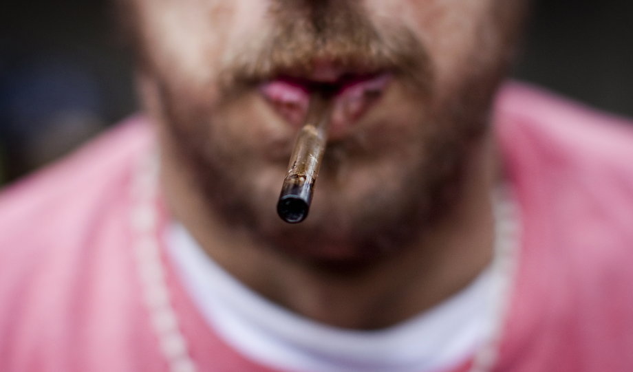 A man holds his used crack pipe in his mouth in Vancouver's Downtown Eastside (DTES) neighborhood, British Columbia, February 11, 2014.