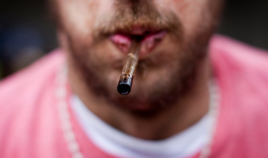 A man holds his used crack pipe in his mouth in Vancouver's Downtown Eastside (DTES) neighborhood, British Columbia, February 11, 2014.