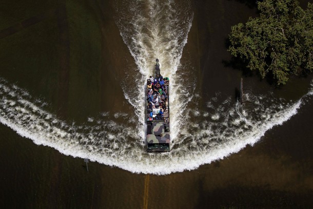 A military vehicle evacuates residents through flood waters caused by Tropical Storm Harvey in Port 