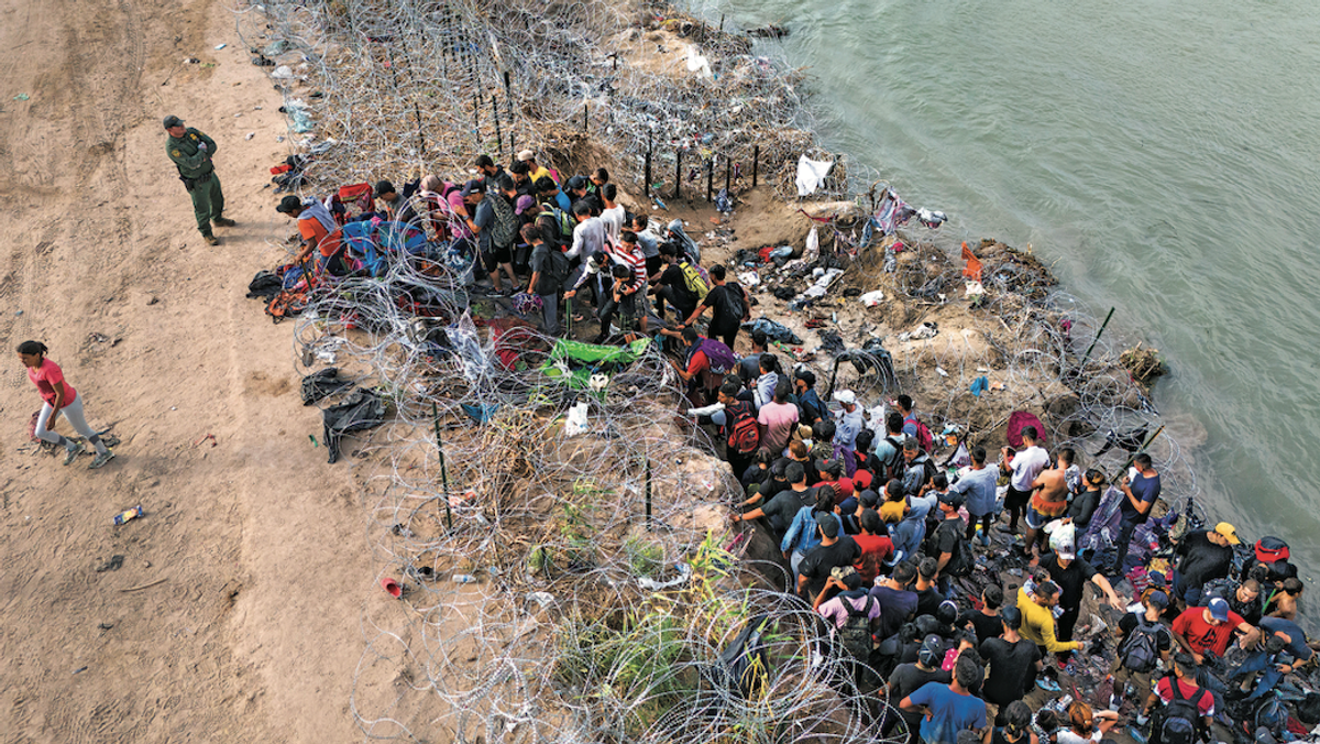 MONITORING Asylum seekers supervised by border control agents who cut wire to allow entry to Texas for processing.