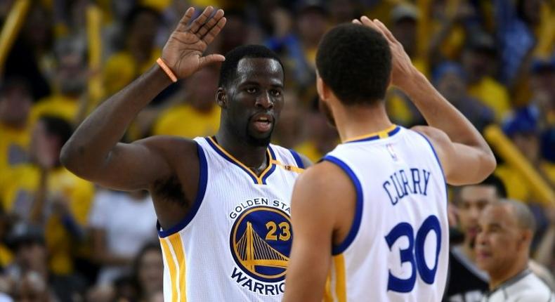 Draymond Green (L) and Stephen Curry of the Golden State Warriors celebrate after a basket against the San Antonio Spurs in Game One of the NBA Western Conference Finals, at ORACLE Arena in Oakland, California, on May 14, 2017