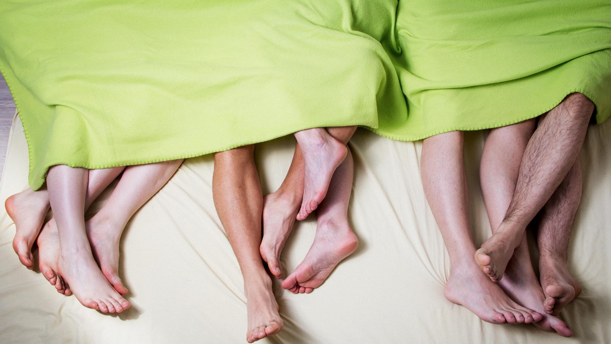 Low Section Of People In Bed