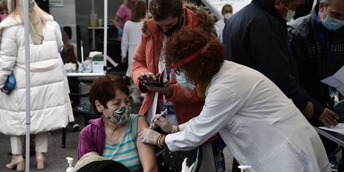 Pacjent otrzymuje dawkę szczepionki przeciwko COVID-19 na Placu Arystotelesa w centrum Salonik, 26 listopada 2021 r.