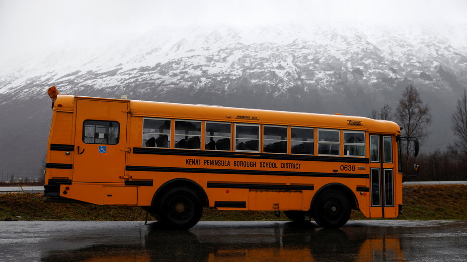 Autobus szkolny na parkingu turystycznego miasteczka w Parku Stanowym Chugach podczas ulewnego deszczu w Girdwood na Alasce. 