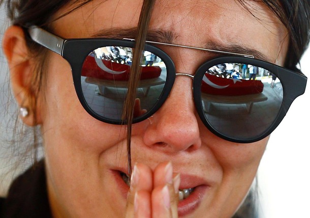 A friend of a victim of Tuesday's attack on Ataturk airport mourns at her flag-draped coffin during 