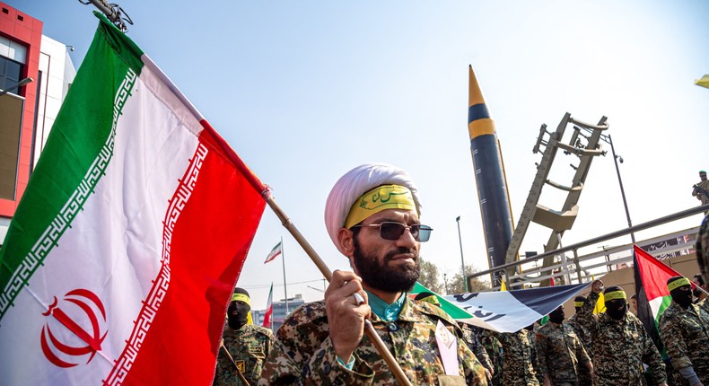 Protesters and members of the Iranian paramilitary's Basij forces march next to a ballistic missile on display during an anti-Israel rally in Tehran in November 2023.Photo by HOSSEIN BERIS/Middle East Images/AFP via Getty Images