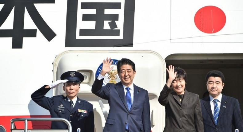 Japan's Prime Minister Shinzo Abe (2nd L) and his wife Akie (2nd R) wave to well-wishers prior to boarding a government plane at Tokyo's Haneda airport on November 17, 2016