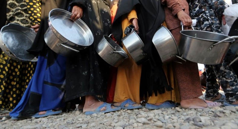 Displaced Iraqis receive aid food during the Muslim holy month of Ramadan at al-Khazir camp for the internally displaced, located between Arbil and Mosul, on June 5, 2017