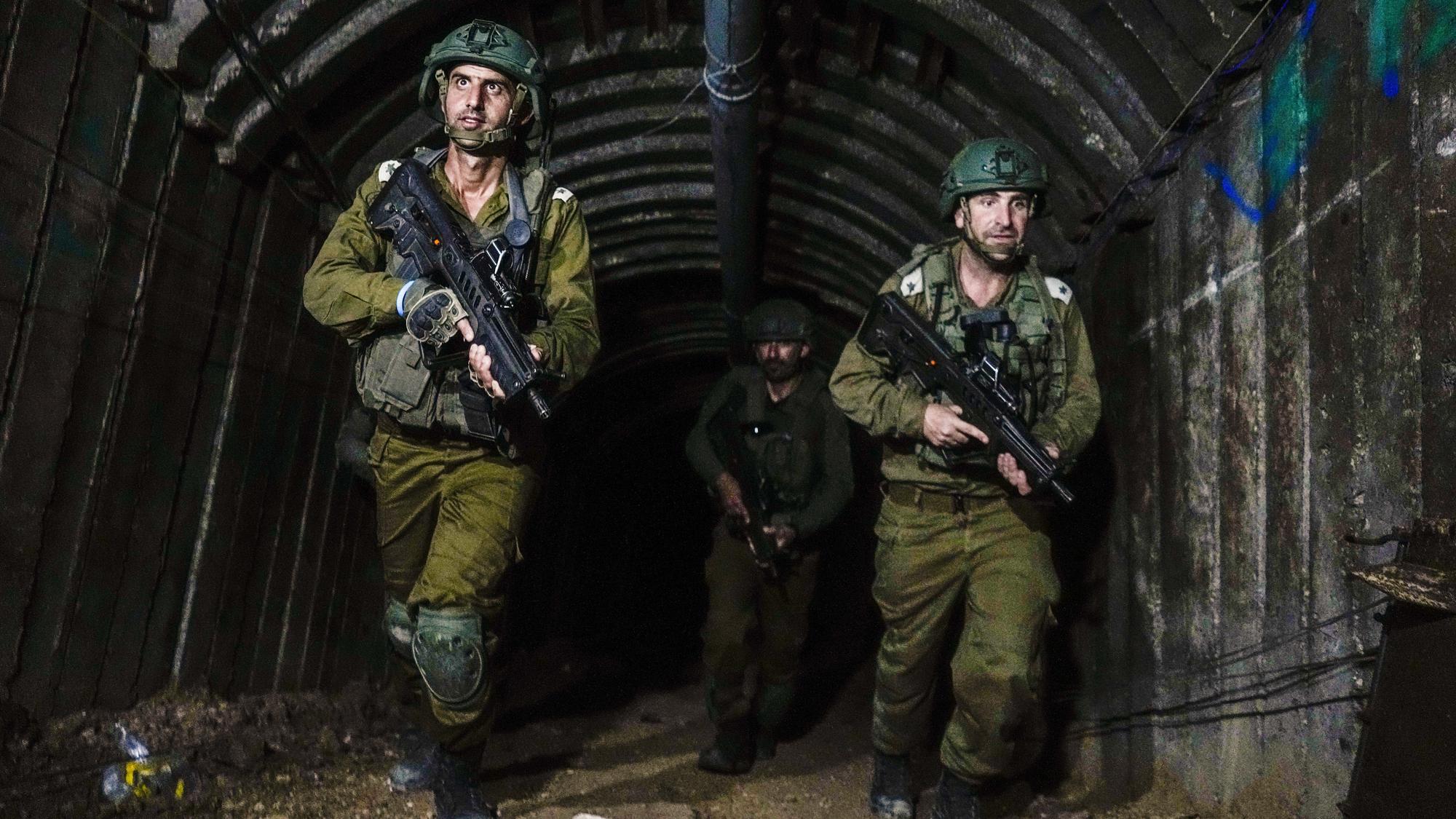 Izraelskí vojaci kráčajú v podzemnom tuneli, ktorý podľa armády použili príslušníci palestínskeho militantného hnutia Hamas na prepadnutie hraničného priechodu  Erez medzi Izraelom a Pásmom Gazy v piatok 15. decembra 2023.