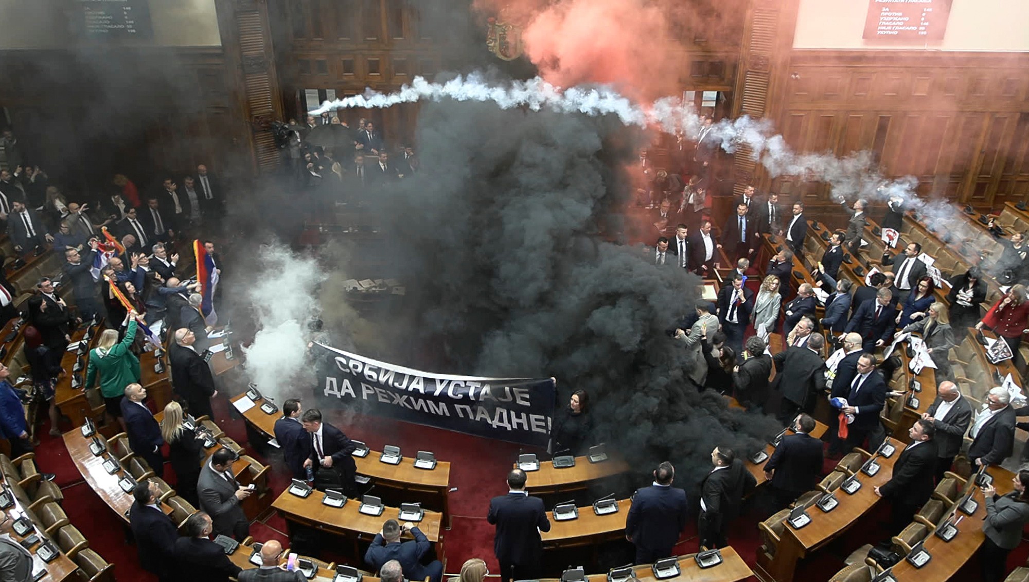 Dymovnice a svetlice vypustené počas zasadnutia parlamentu v Belehrade.