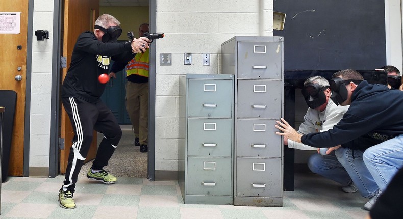 An 'active shooter' enters a classroom as 'students' take cover during ALICE (Alert, Lockdown, Inform, Counter and Evacuate) training at the Harry S. Truman High School in Levittown, Pennsylvania, on November 3, 2015.