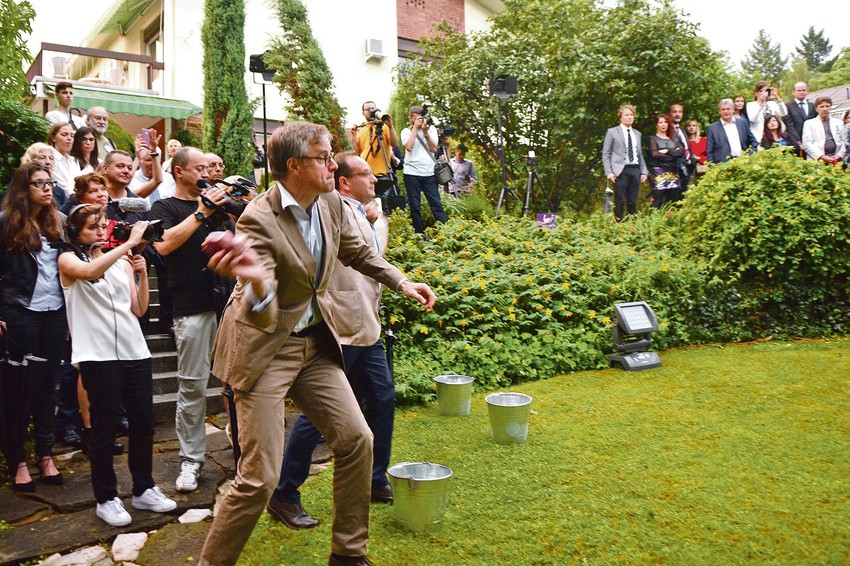 Nemački ambasador u Srbiji Aksel Ditman i njegov italijanski kolega Đuzepe Manca bacaju svinjska srca ka umetnici 