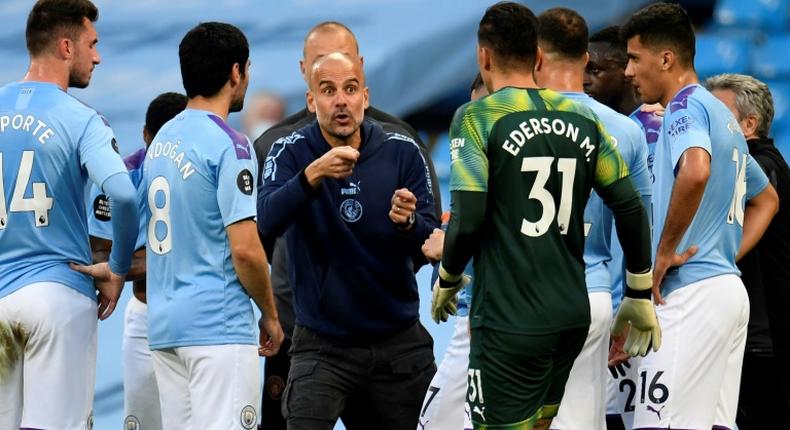 Pep Guardiola (centre) says he has to earn a new contract at Manchester City this season