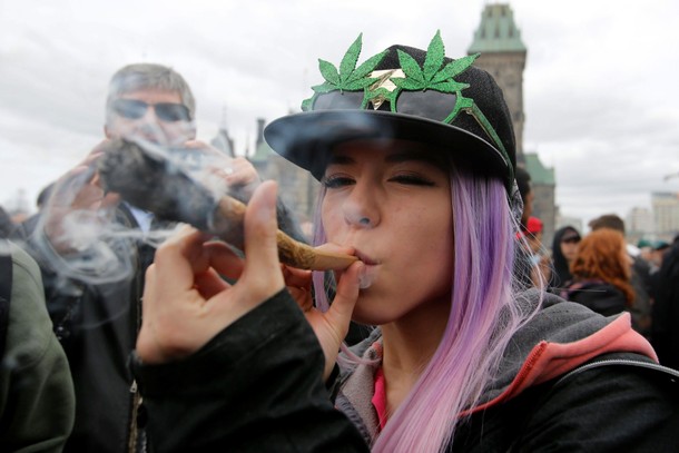 A woman smokes marijuana during the annual 4/20 marijuana rally on Parliament Hill in Ottawa