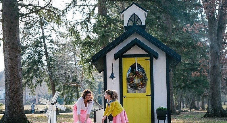 Hughes and her daughter outside of the Chapel Coop model.
