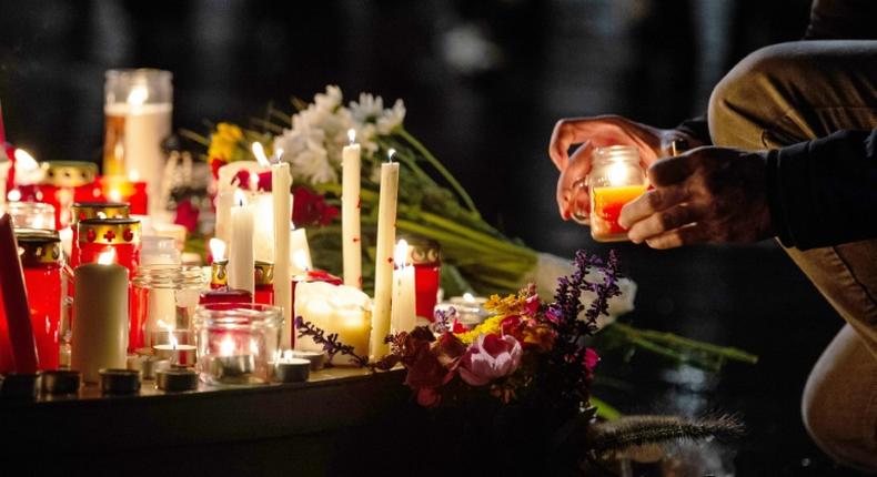 People leave candles and flowers at a vigil at the Marktplatz in Halle, eastern Germany