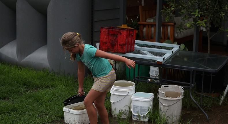 Eight-year-old Chelsea Symonds carries a bucket of collected rainwater in her family's yard in the drought-affected town of Murrurundi, New South Wales, Australia, on February 17, 2020.