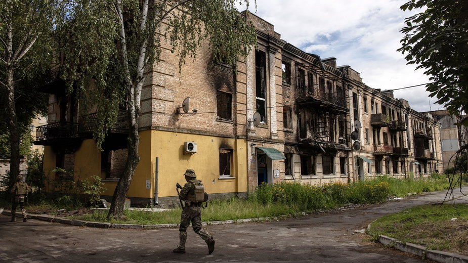 Ukraiński żołnierz w osiedlu zniszczonym podczas rosyjskiego ataku na przedmieścia Kijowa na początku wojny 