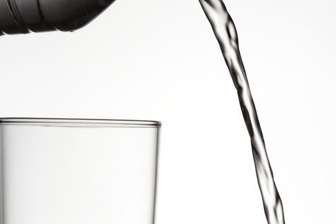 Close-up of water being poured outside of a glass