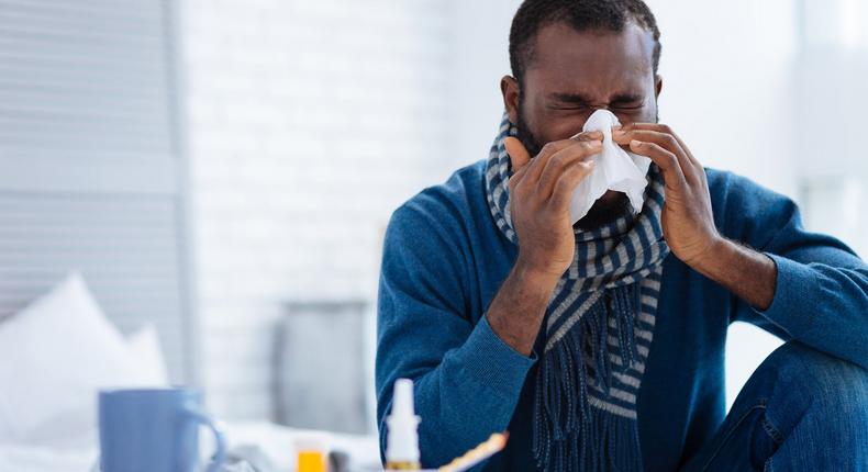 man sneeze sick cold tissue blow nose